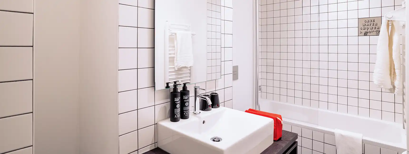 Salle de bain avec lavabo et baignoire au fond - chambre familiale rockypop marseille