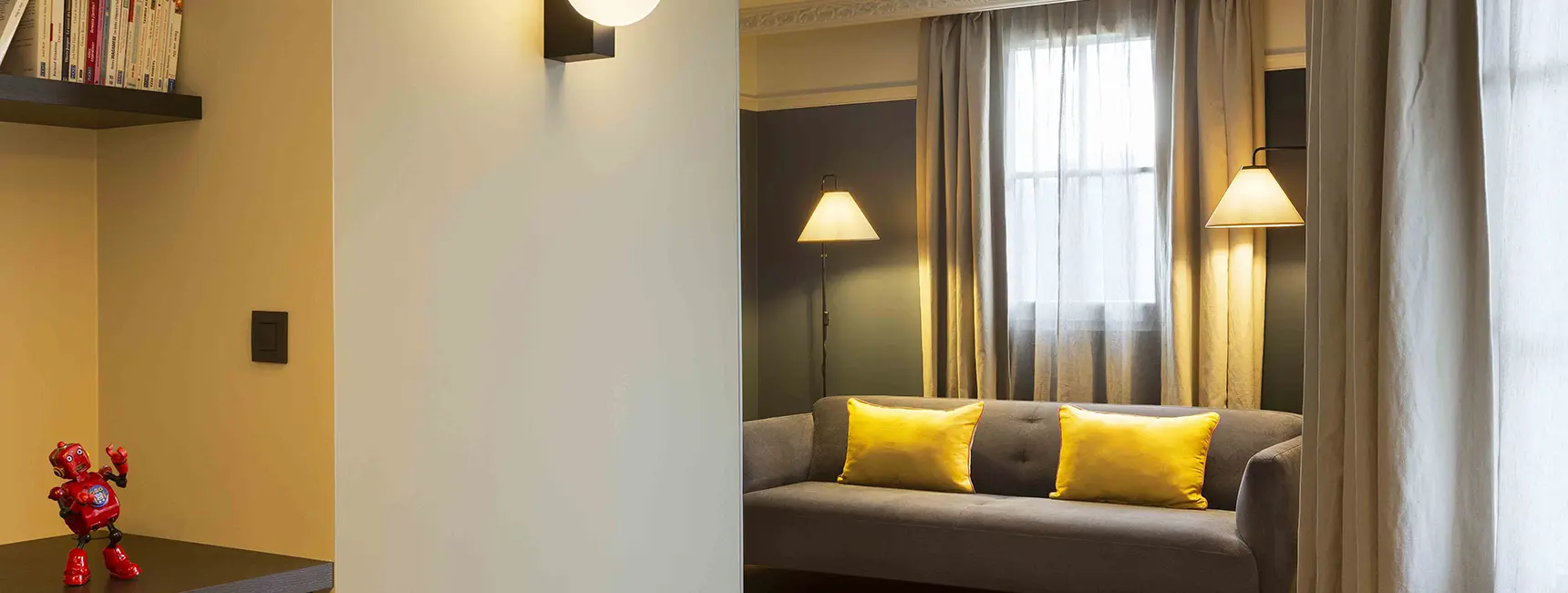 Canapé confortable avec coussins et éclairage chaleureux – penthouse RockyPop Grenoble