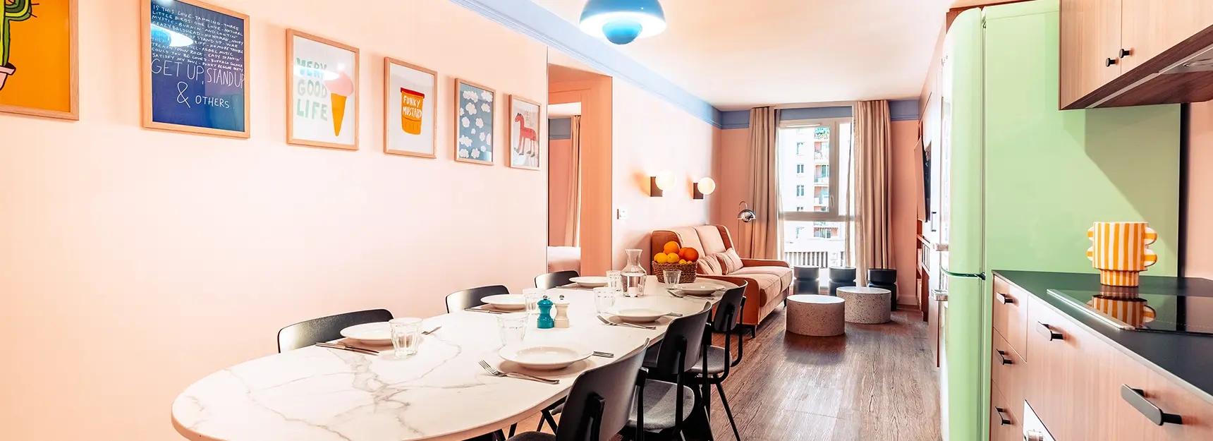 Grande pièce à vivre avec table dressée à gauche, cuisine à droite, coin salon avec canapé et TV au fond et chambre au fond à gauche - rockypop marseille