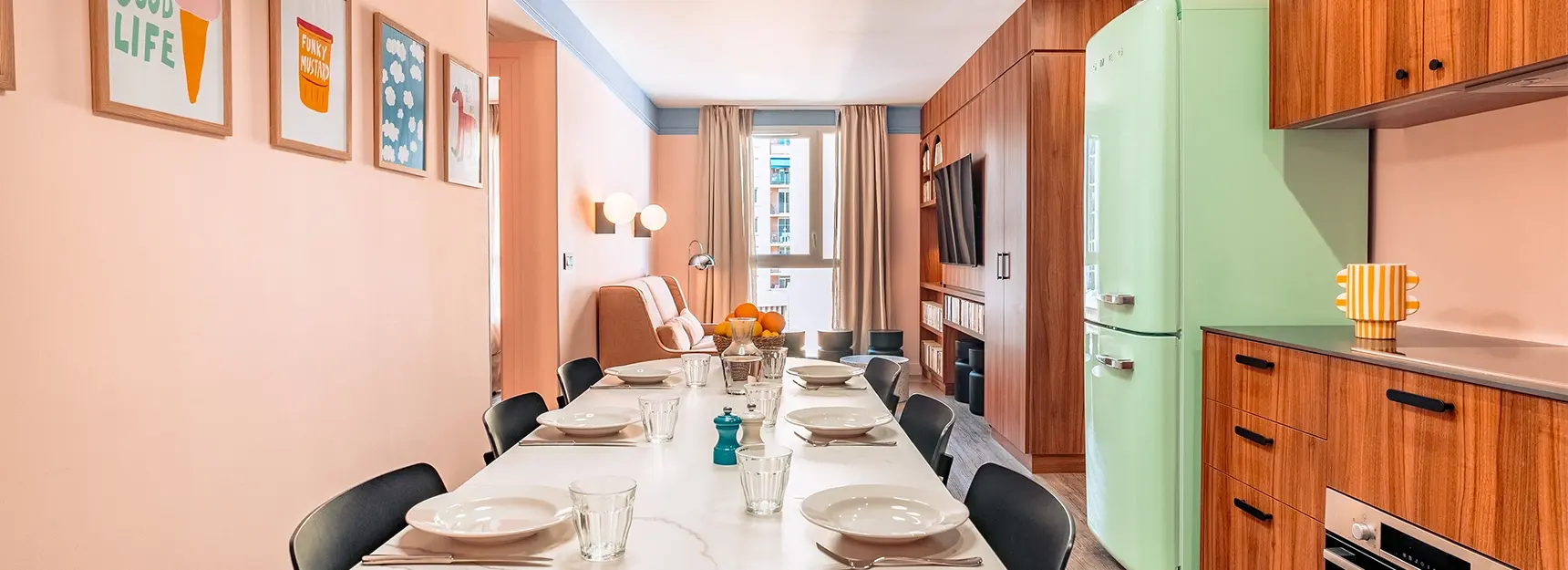 Grande pièce à vivre avec table dressée au centre, cuisine à droite, coin salon avec canapé et TV au fond et chambre au fond à gauche - rockypop marseille