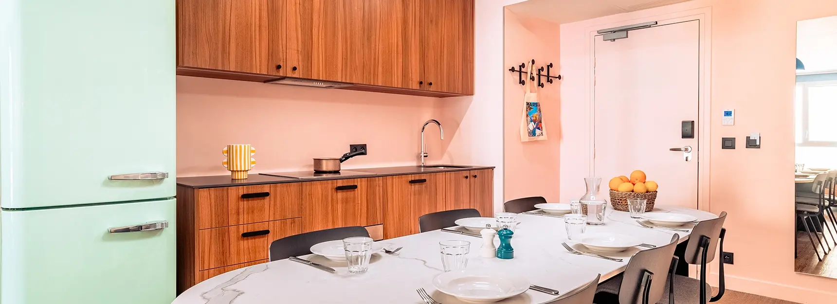 Entrée de l'appartement avec table dressée et cuisine au fond - rockypop marseille