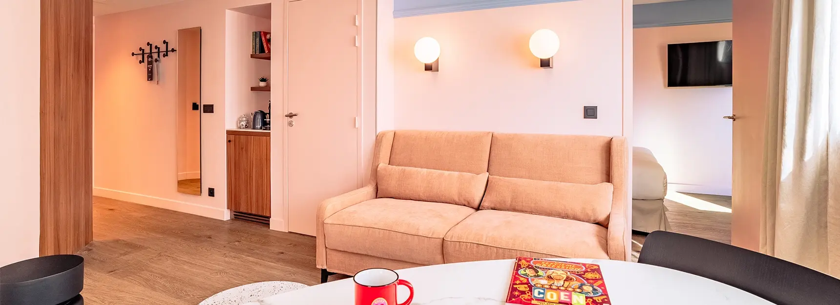 Pièce à vivre avec coin salon, table et canapé convertible, chambre à droite - rockypop marseille