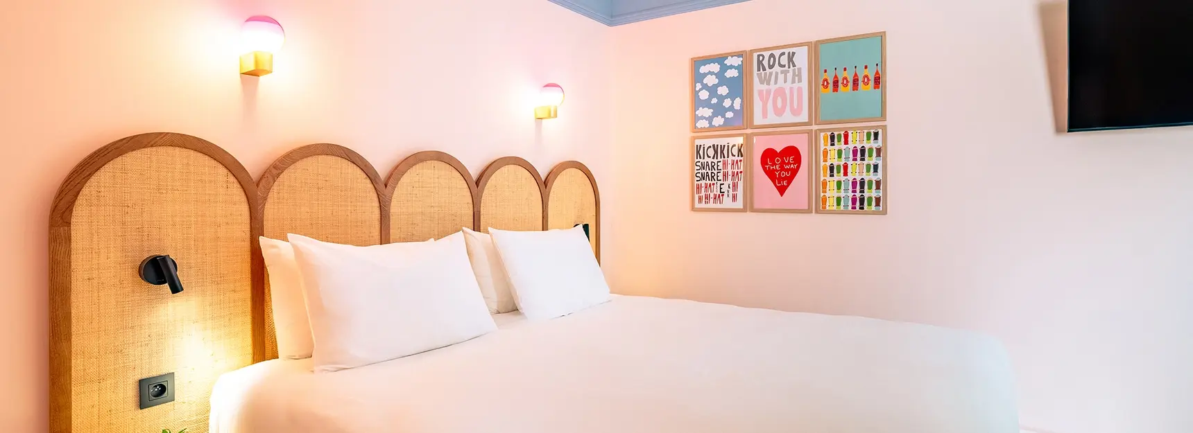 Chambre avec lit double à gauche et cadres colorés au fond - rockypop marseille