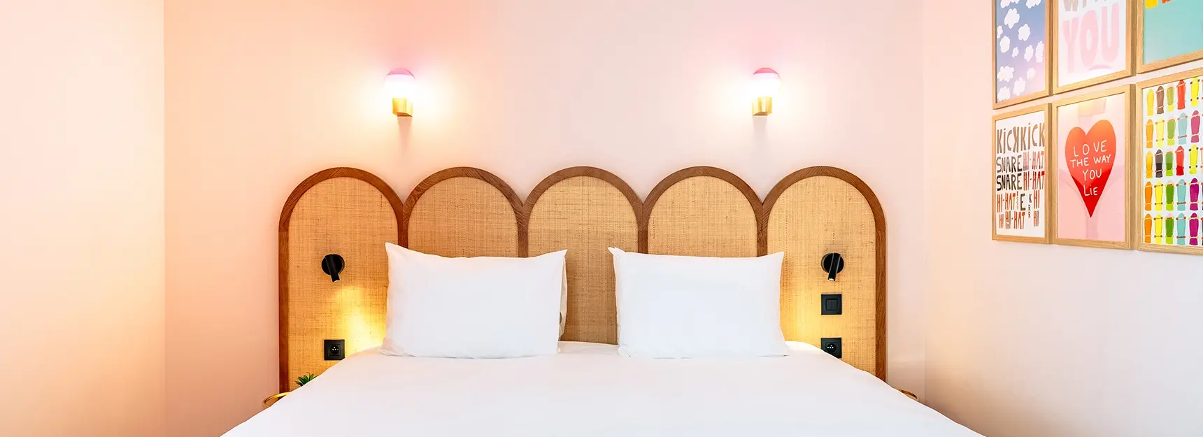 Chambre avec lit vu de face et cadres colorés à droite - rockypop marseille