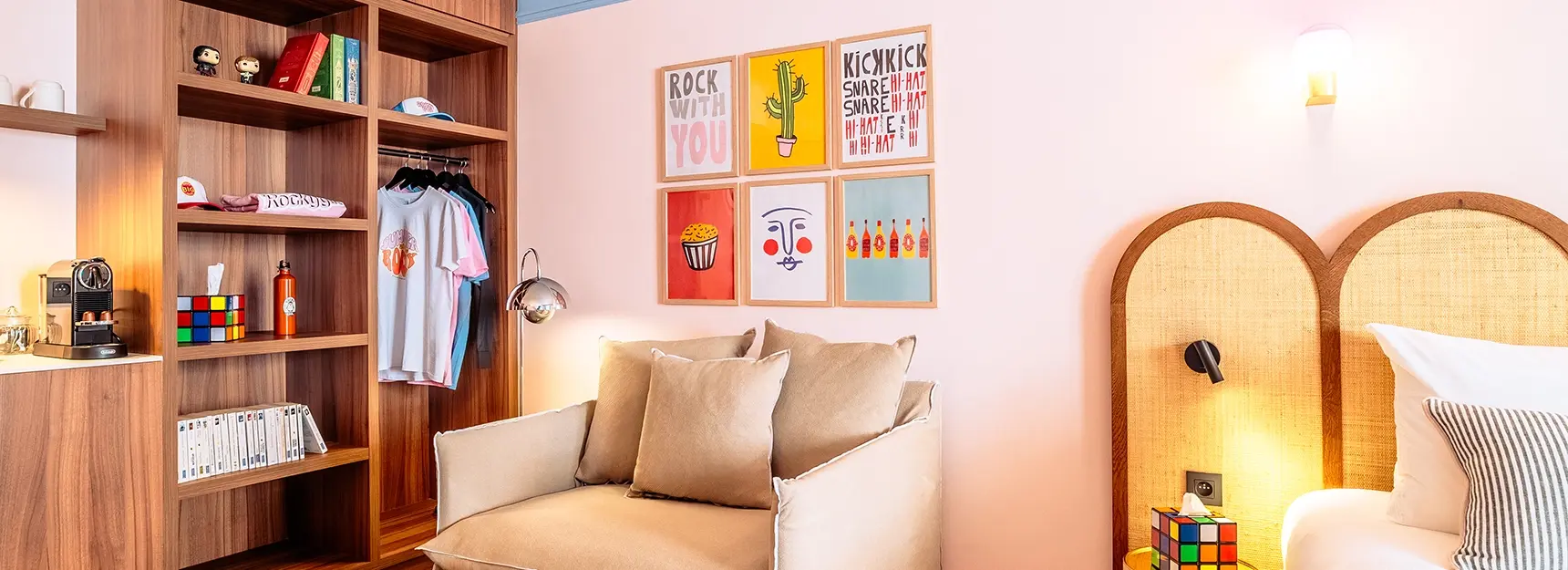 Canapé convertible au centre, plan de travail avec cafetière et bouilloire à gauche, placard de rangement et partie du lit double visible à droite – RockyPop Marseille