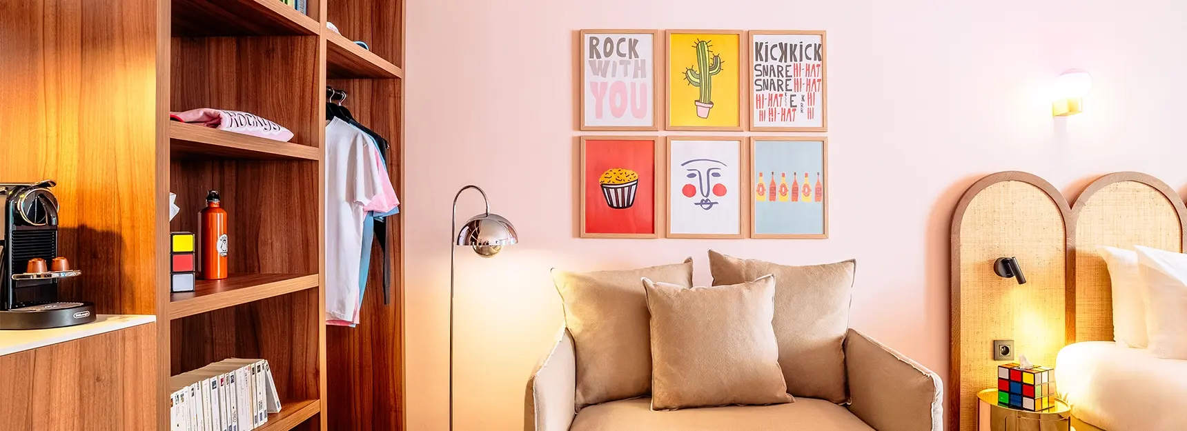 Canapé convertible au centre, plan de travail avec cafetière et bouilloire à gauche, placard de rangement et partie du lit double visible à droite – RockyPop Marseille