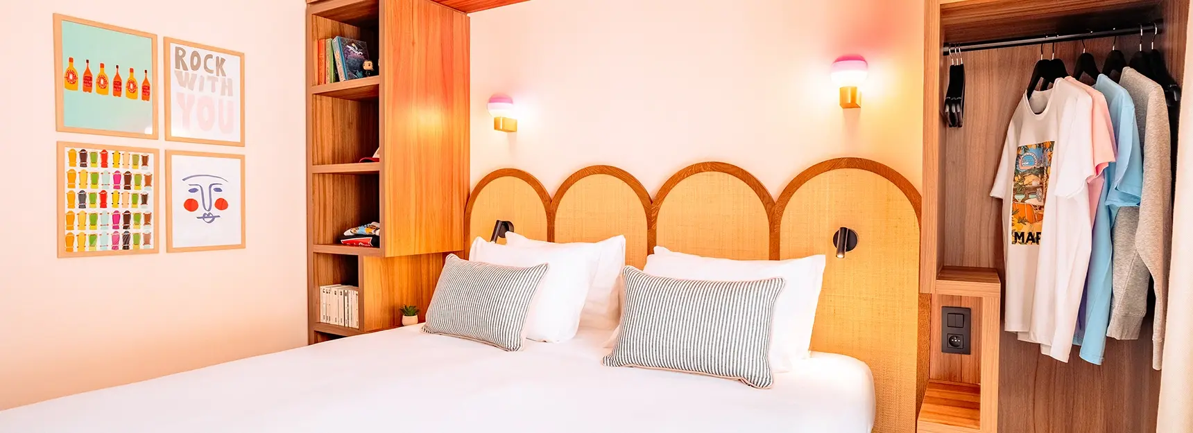 Vue sur une chambre avec lit double et rangement autour du lit, cadres déco colorés à gauche - rockypop marseille