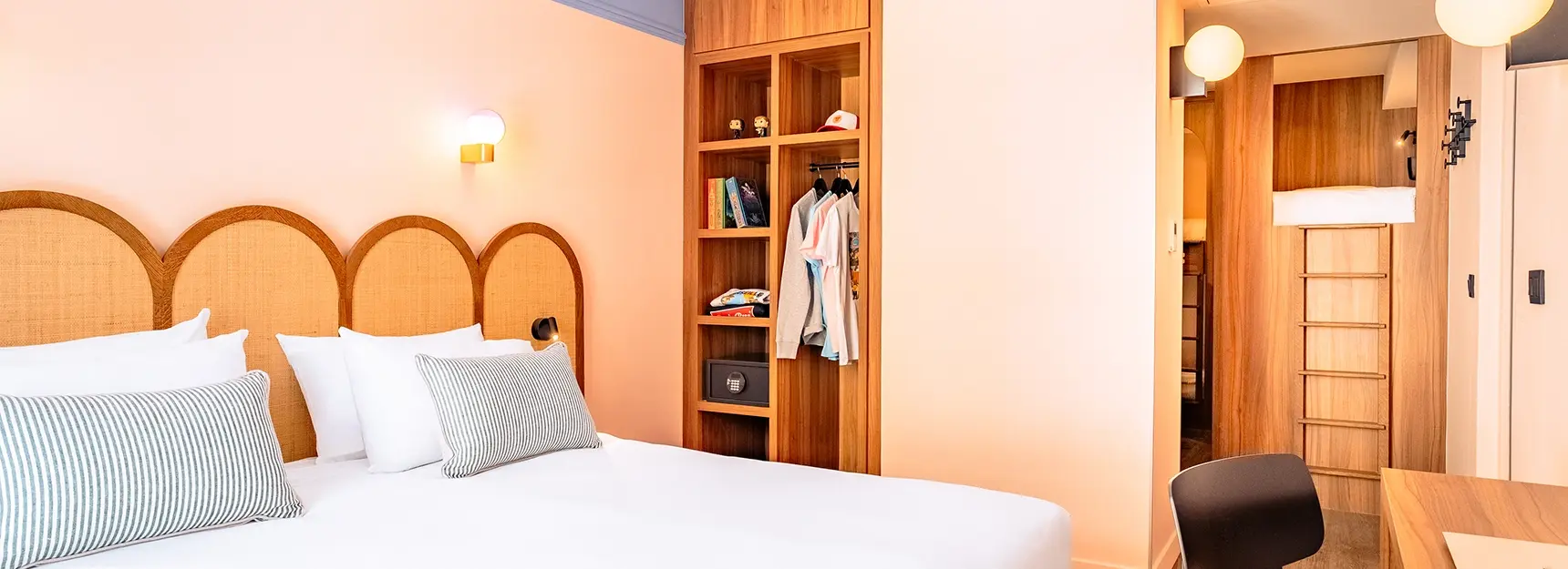 Vue sur une chambre avec un lit double à gauche, un bureau à droite et au fond une pièce avec des lits superposés - rockypop marseille