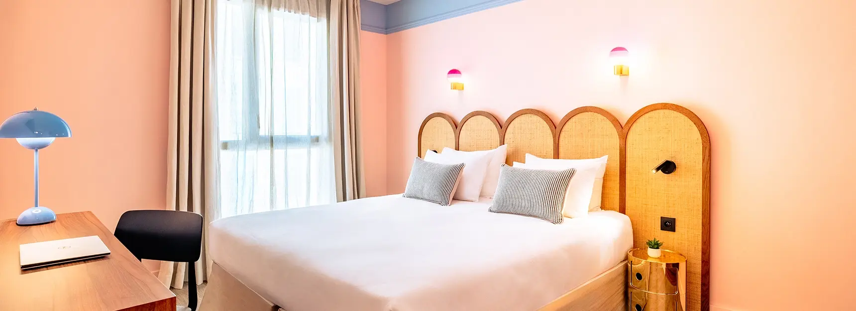 Vue sur une chambre spacieuse avec lit double au centre, grande fenêtre au fond et bureau à gauche - rockypop marseille
