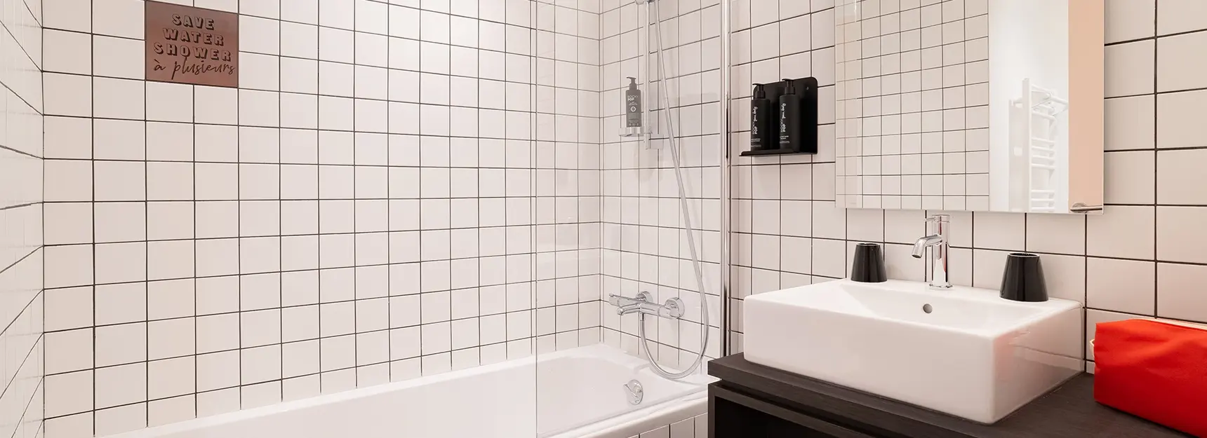 Salle de bain avec baignoire au fond et lavabo à droite - rockypop marseille