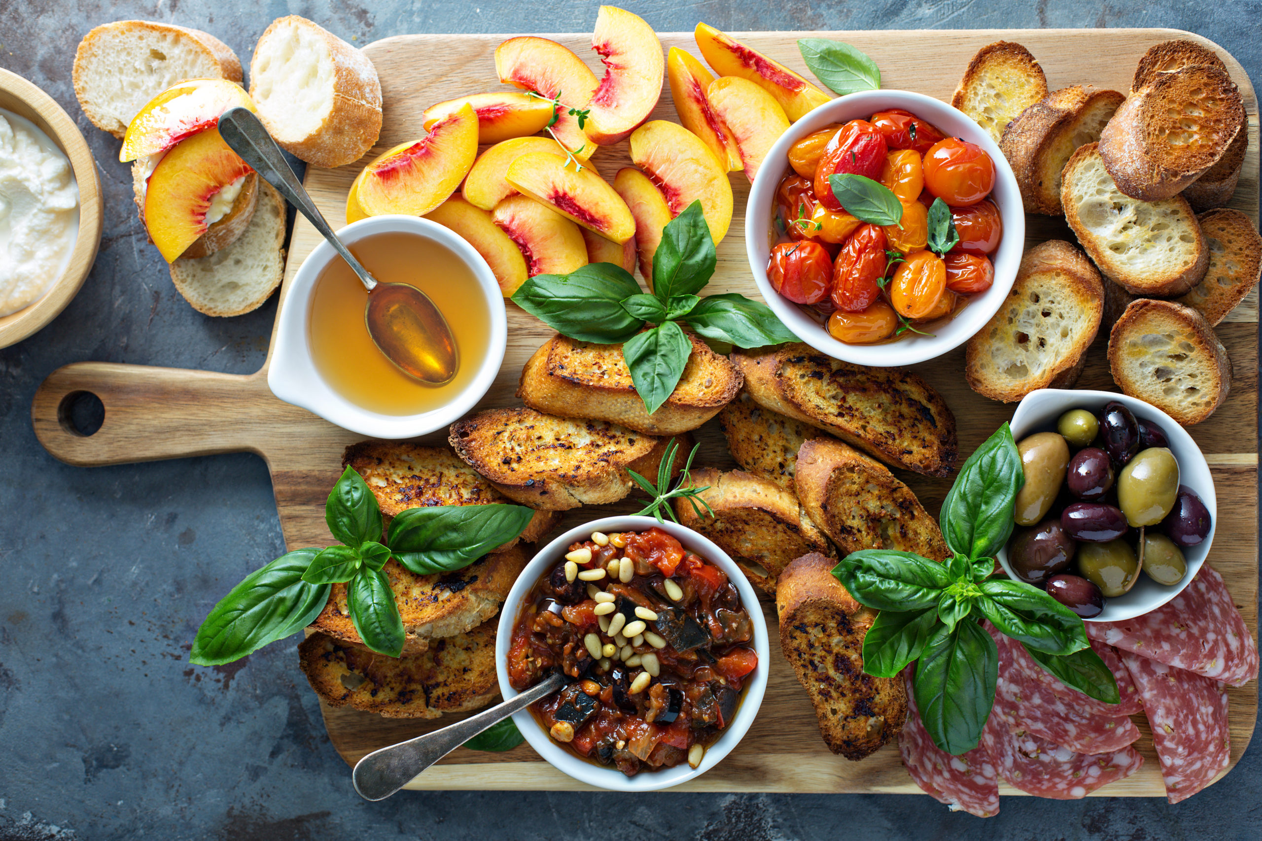 Crostini board with tomatoes, peaches and dip